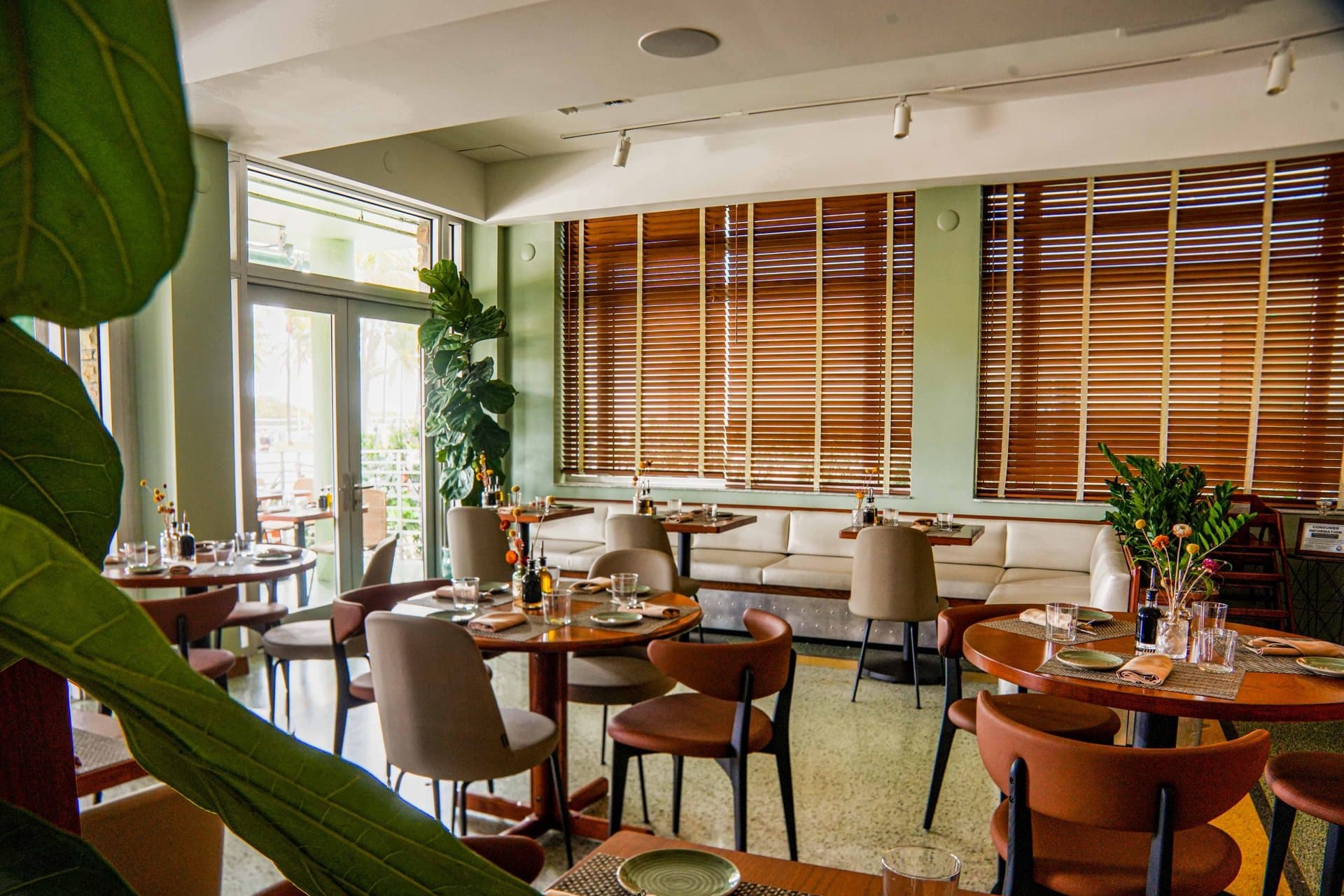 Dining room at Pelican Restaurant with wooden blinds and green walls, Ocean Drive, Miami Beach