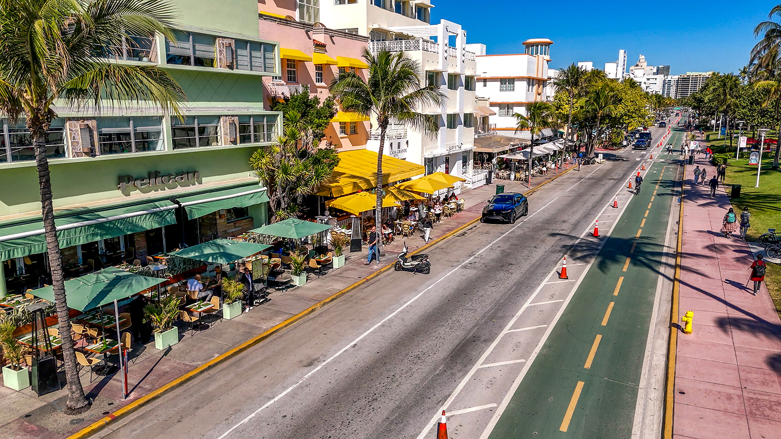 The Pelican Hotel and its terrace with green umbrellas on Ocean Drive, Miami Beach