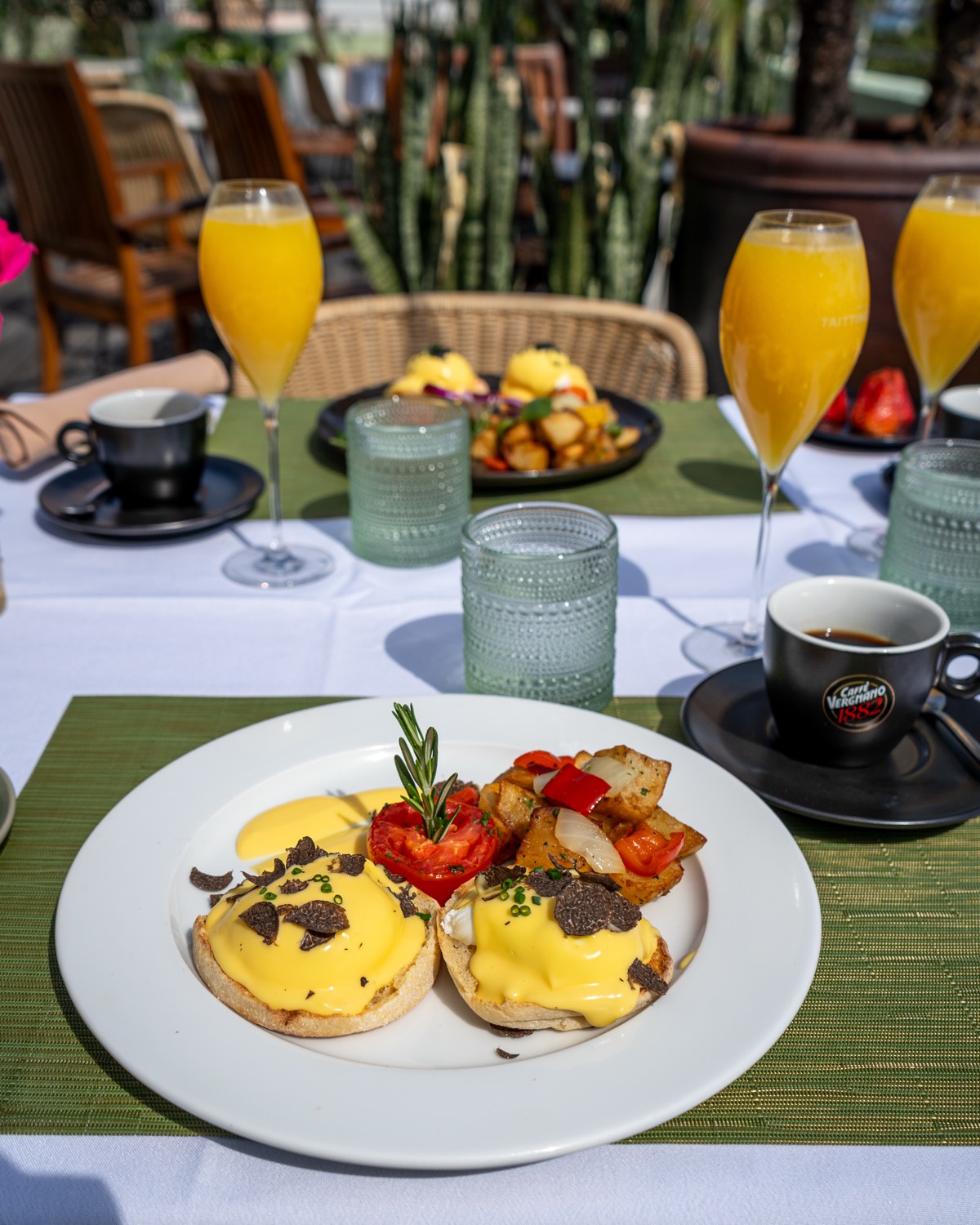 Eggs Benedict with hollandaise and shaved black truffle, house potatoes and roasted tomato at Sunday brunch in Miami Beach