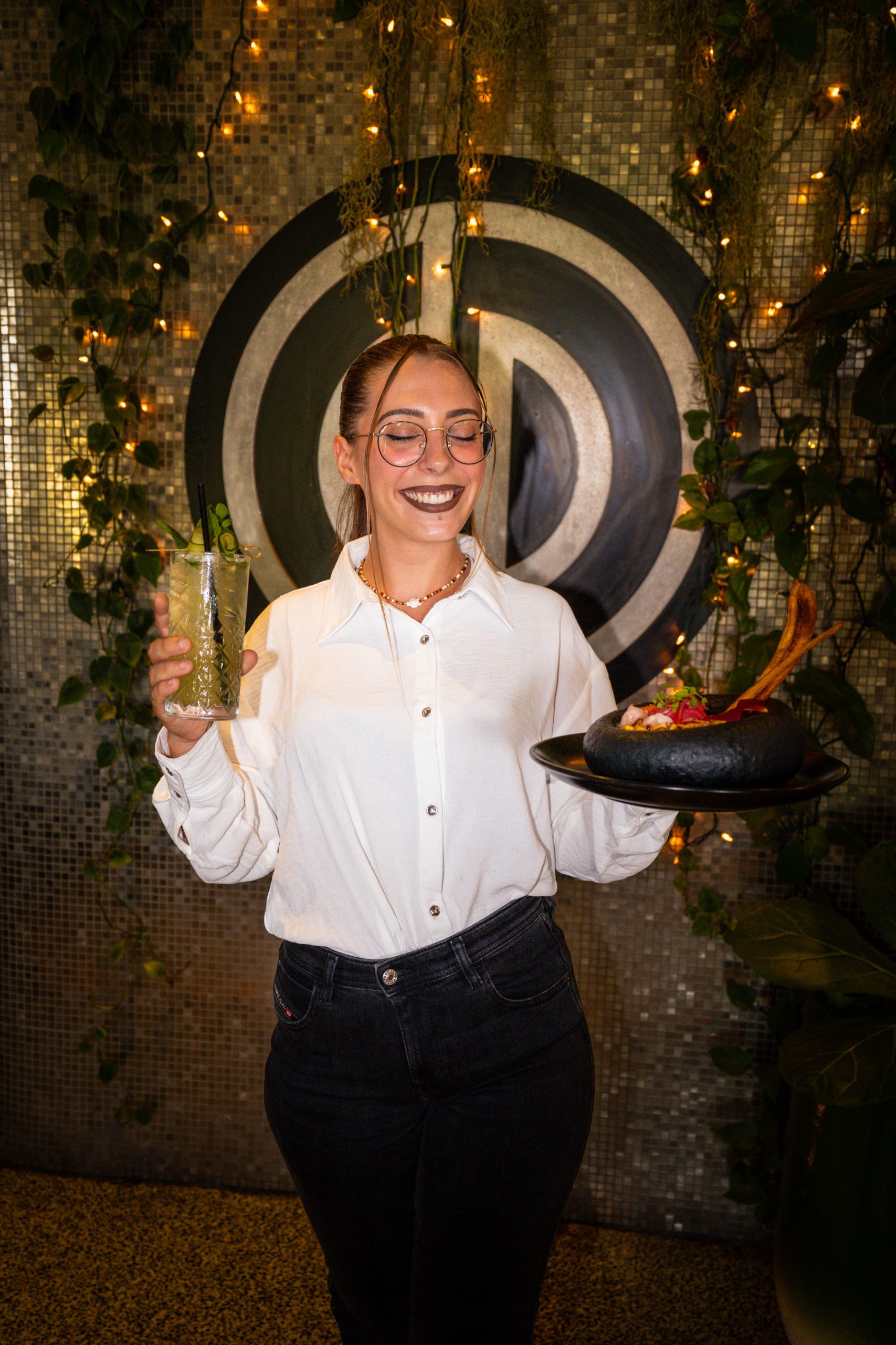 A server bringing a dish and a cocktail at Pelican Restaurant in the evening, Miami Beach
