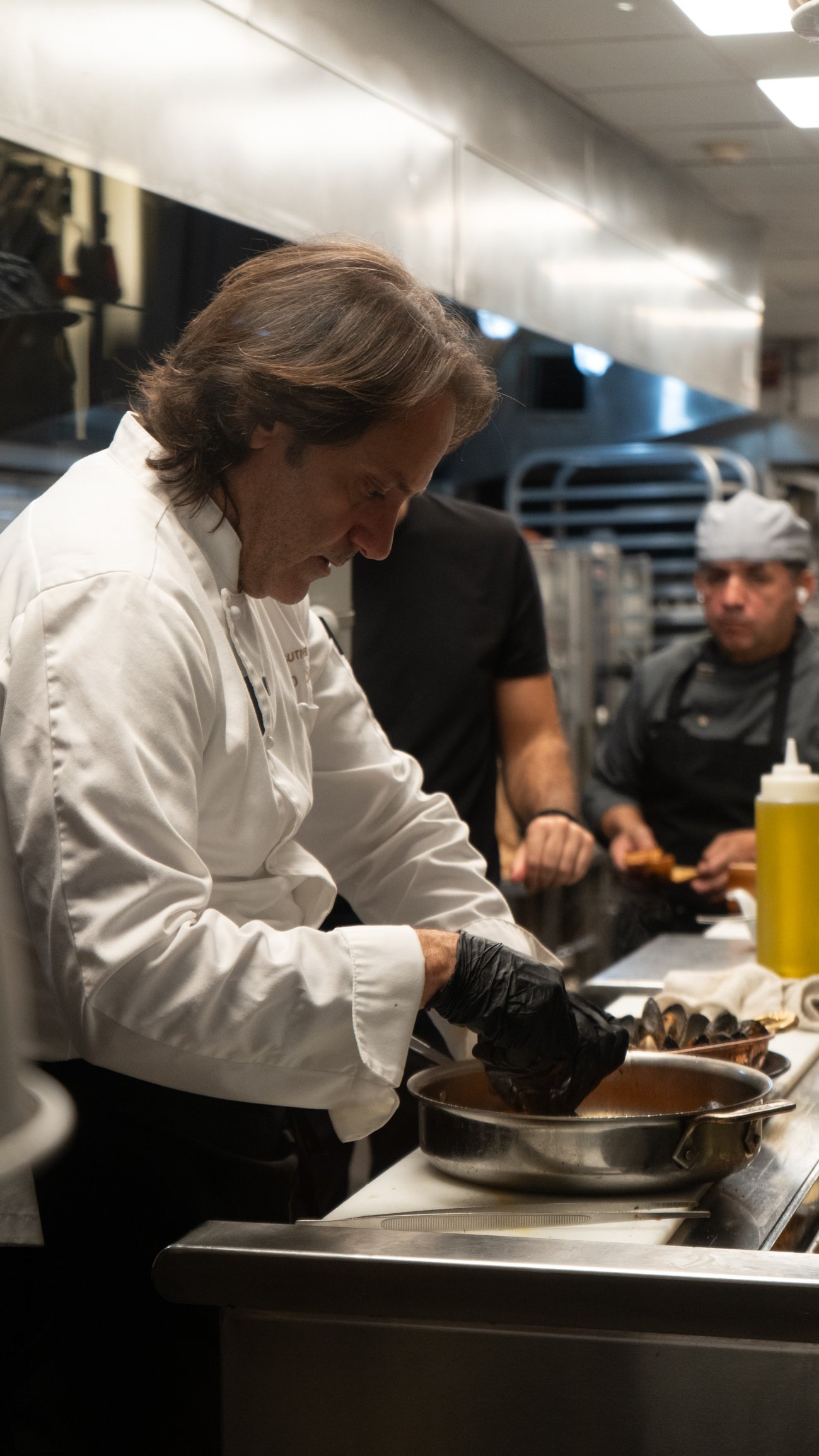 A chef plating a dish in the kitchen at Pelican Restaurant on Ocean Drive